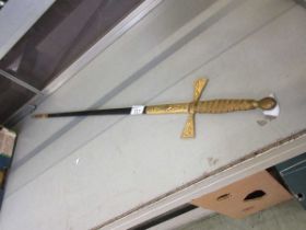 A brass cross handled sword with sheath