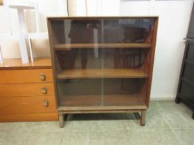 A mid-20th century teak bookcase with two glass sliding doors