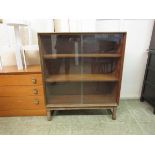 A mid-20th century teak bookcase with two glass sliding doors
