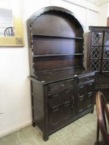 A carved oak Dutch dresser having plate rack to top and two drawers over cupboard doors to base