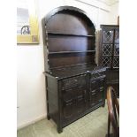 A carved oak Dutch dresser having plate rack to top and two drawers over cupboard doors to base