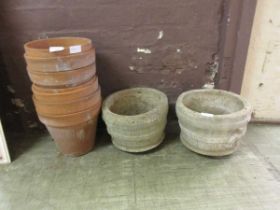 Two stoneware pots together with a collection of clay pots