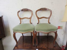 A pair of walnut framed balloon back dining chairs having olive green upholstered seats