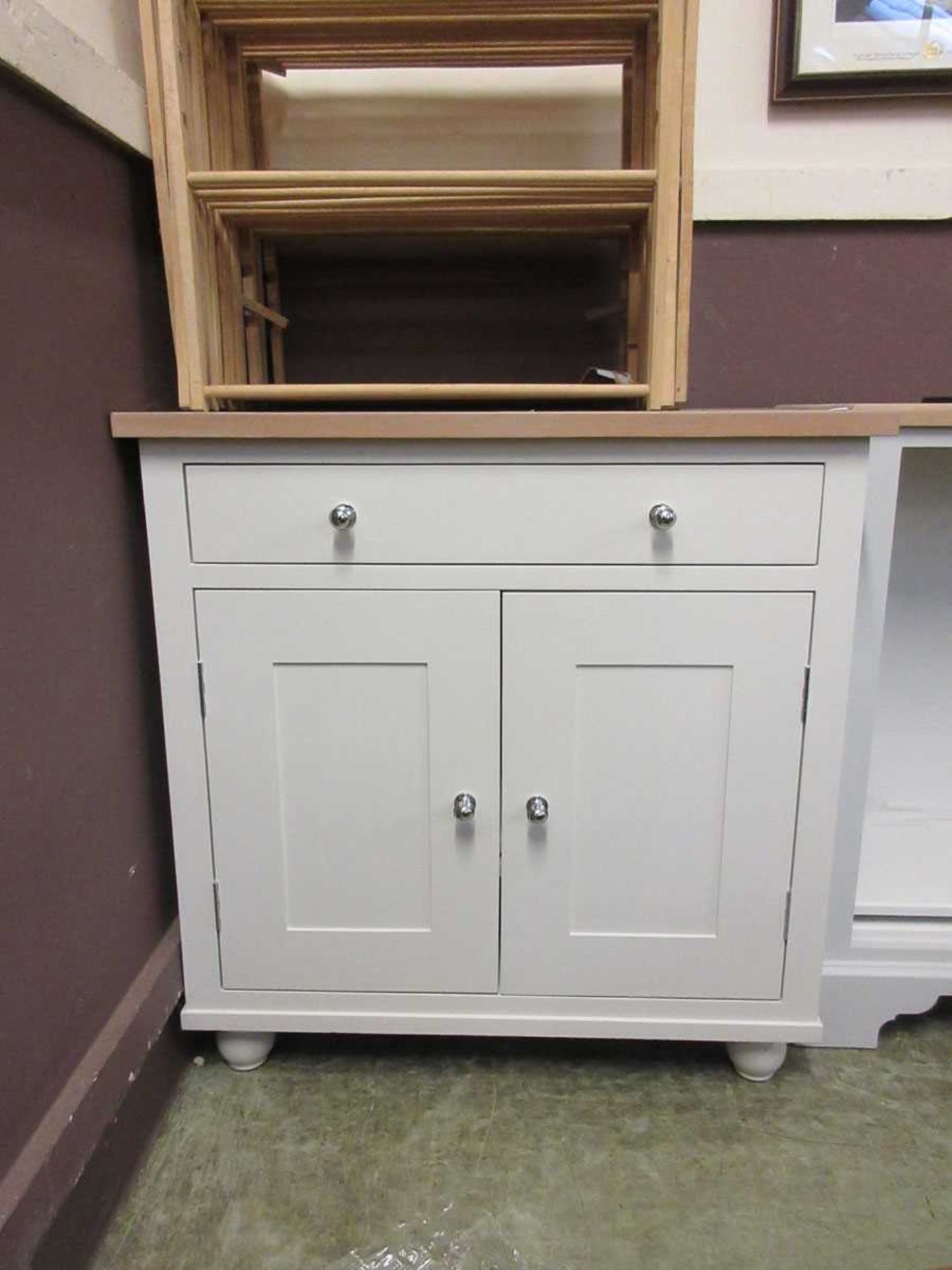 A limed oak effect and white painted cabinet having a single drawer above a pair of cupboard doors