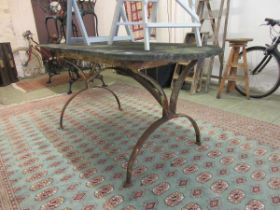 A metalwork table with a weathered stone top