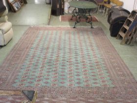 A large rectangular green ground eastern style rug Heavy wear to one corner. Dimensions: L,
