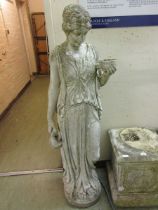 A weathered stone maiden holding cup