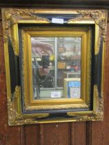 A black painted and gilt framed wall mirror