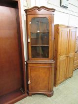 A high quality reproduction walnut effect corner display cabinet having a glazed door to top with
