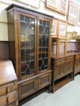 An early 20th century lead glazed bookcase on cupboard base with short barley twist supports
