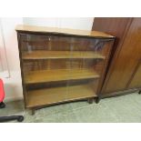 A teak bookcase with glass sliding doors