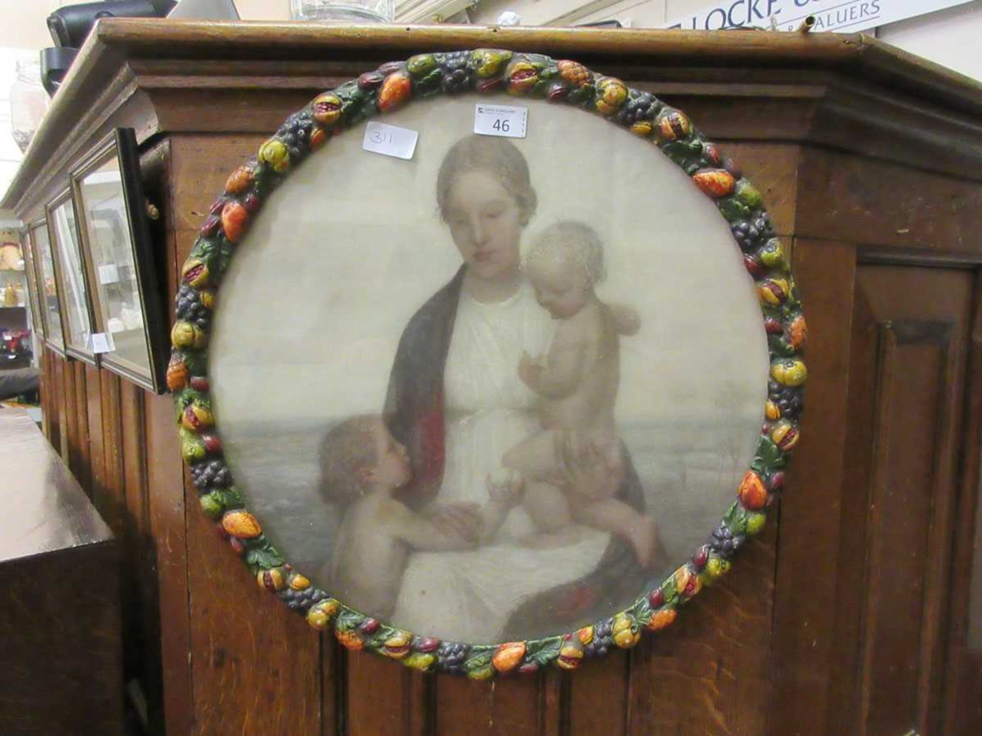 Coloured lithograph, Mary with Jesus and St John the Baptist, moulded fruit frame, 49cm diameter