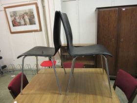 A pair of faux leather upholstered chrome legged chairs