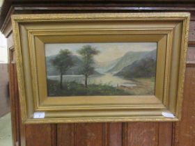 A gilt framed oil on canvas of mountainous lake scene, indistinctly signed to bottom left