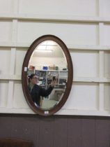 An oak framed oval bevel glass wall mirror