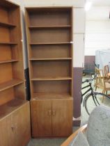 A mid-20th century teak full height bookcase, the four shelves over a pair of cupboard doors