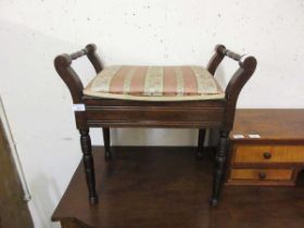 An early 20th century walnut music stool with lift up lid to upholstered seat