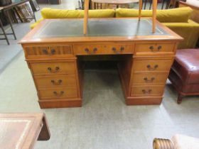 A modern yew effect twin pedestal desk, the green leatherette inset over three drawers over the