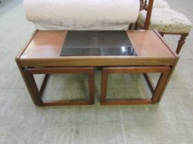 A mid-20th century style teak and smoked glass nest of three occasional tables