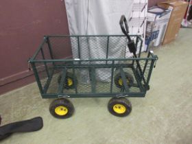 A green metal four wheeled trolley