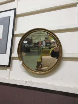 An ornate gilt framed bevel glass circular wall mirror