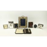A COLLECTION OF SILVERWARE, comprising Rococo embossed photo frame, three smaller photo frames, a
