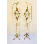 STORM LANTERNS ON STANDS, a pair, 163cm high, 36cm wide, 30cm deep, in the Regency style, gilt metal