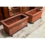 ITALIAN GARDEN TROUGH PLANTERS, a pair, weathered terracotta raised on glazed loose ceramic feet,