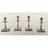 CANDLESTICKS, a set of four, silvered, probably early 20th century with column and square bases,