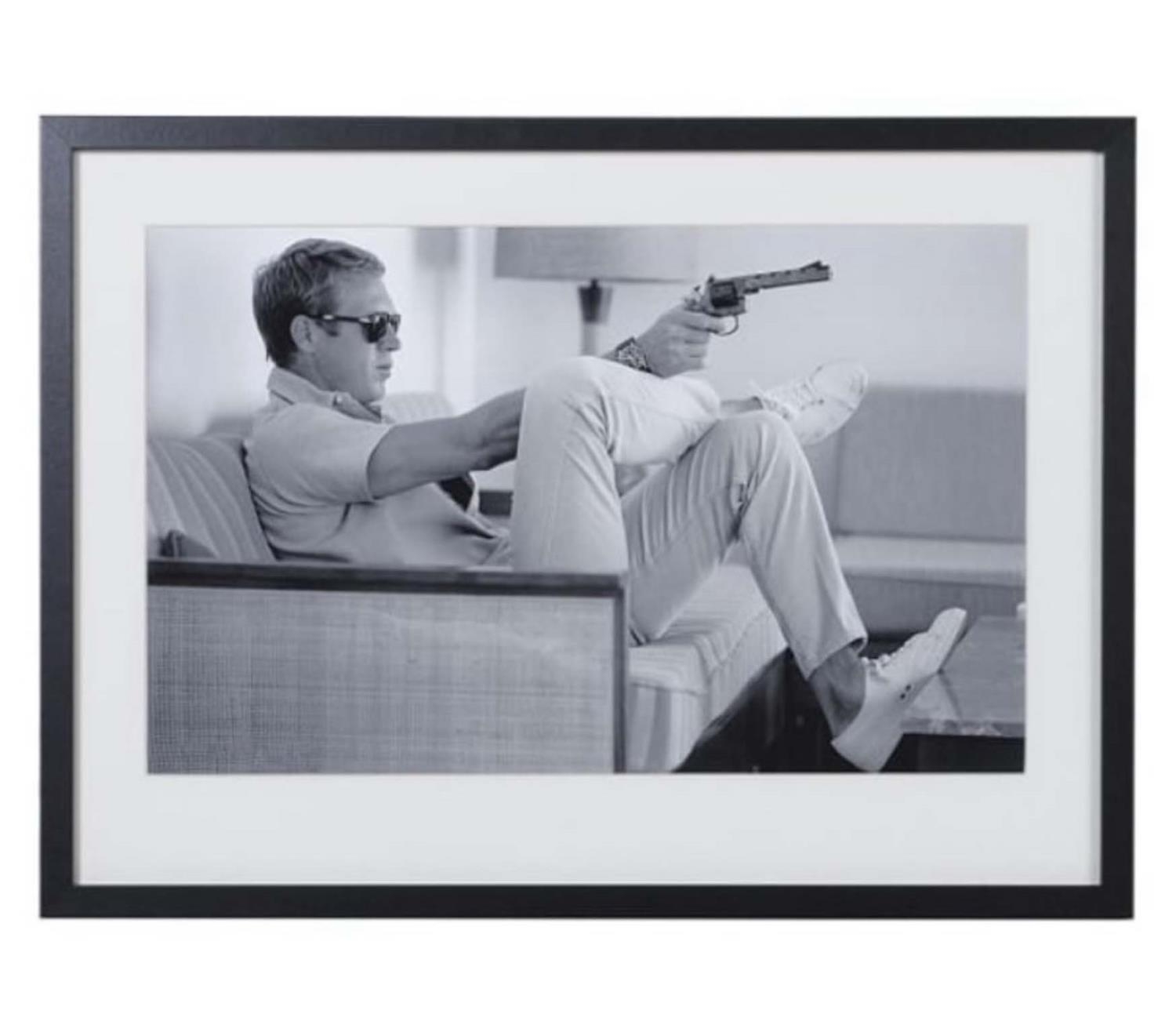 AFTER JOHN DOWNING, Steve McQueen with gun, 54cm x 74cm, framed and glazed.