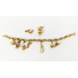 AN 18CT GOLD CHARM BRACELET, fitted with seven charms, plus two further loose charms, 21cm long,