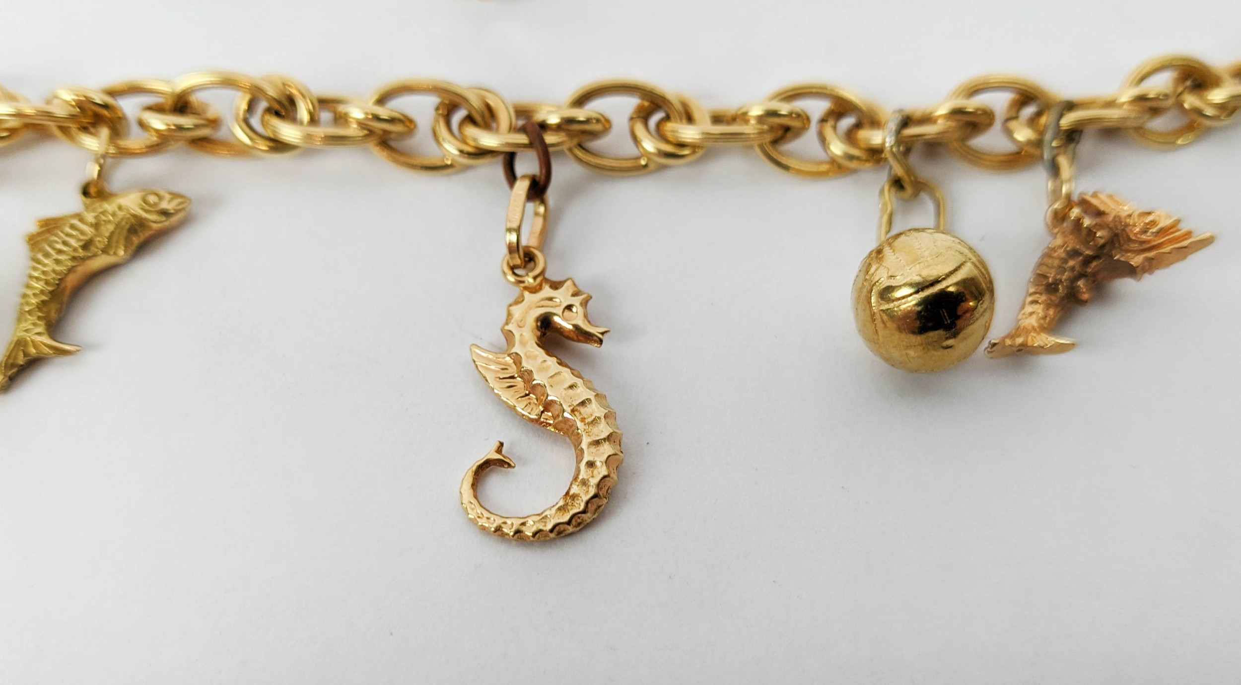 AN 18CT GOLD CHARM BRACELET, fitted with seven charms, plus two further loose charms, 21cm long, - Image 4 of 8