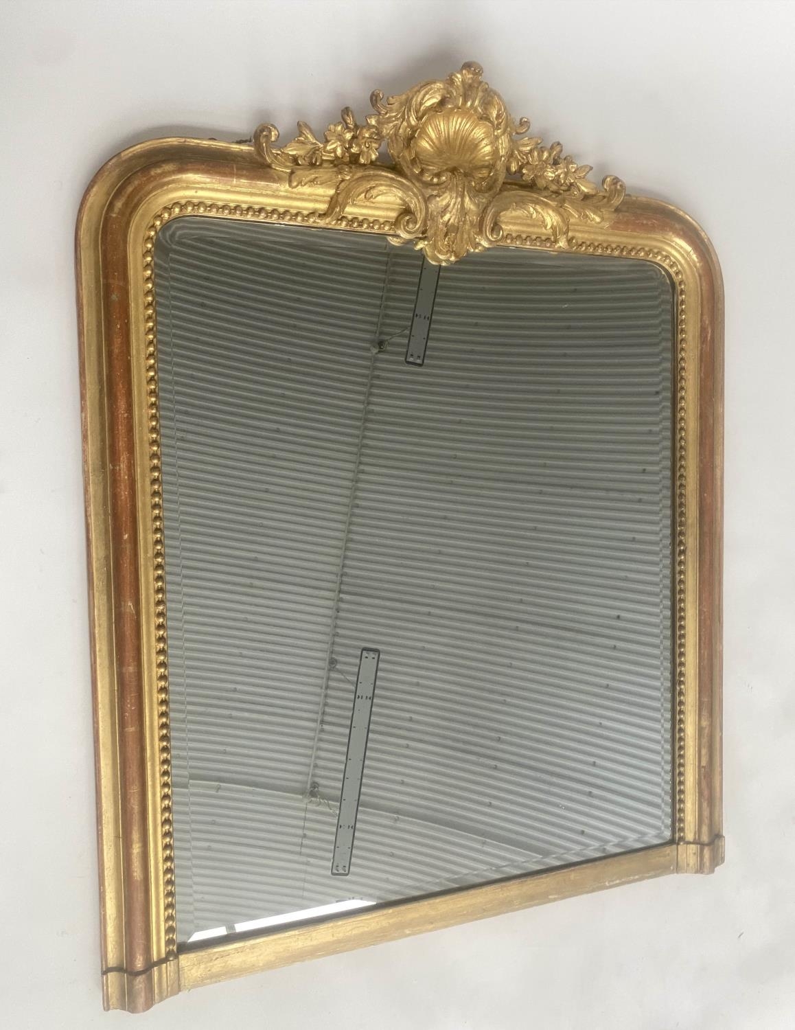 OVERMANTEL MIRROR, 19th century French giltwood and gesso moulded with arched beaded frame and shell