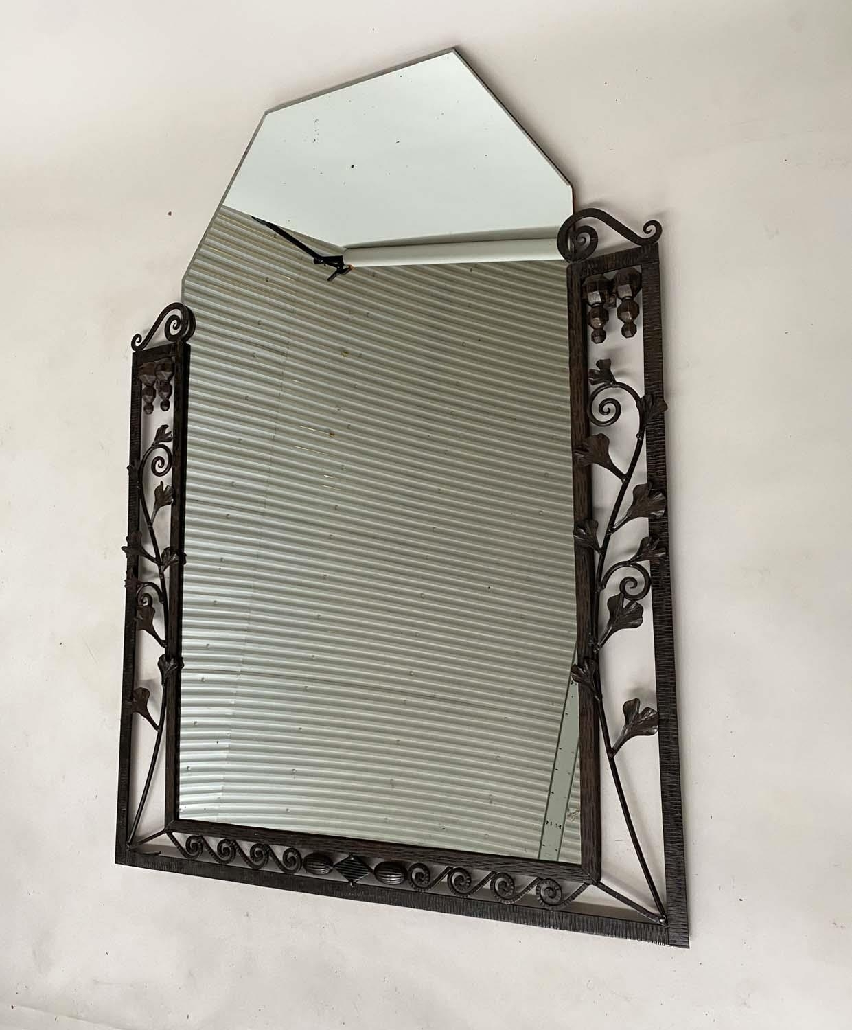 ART DECO WALL MIRROR, French bevelled tapering mirror within a wrought iron foliate and Vitruvian