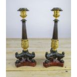 CANDLESTICKS, a pair, 19th century Empire style with paw feet on a red mottled base, 33cm H. (2)