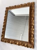 WALL MIRROR, Italian carved giltwood rectangular with bevelled plate and foliate carved frame by '