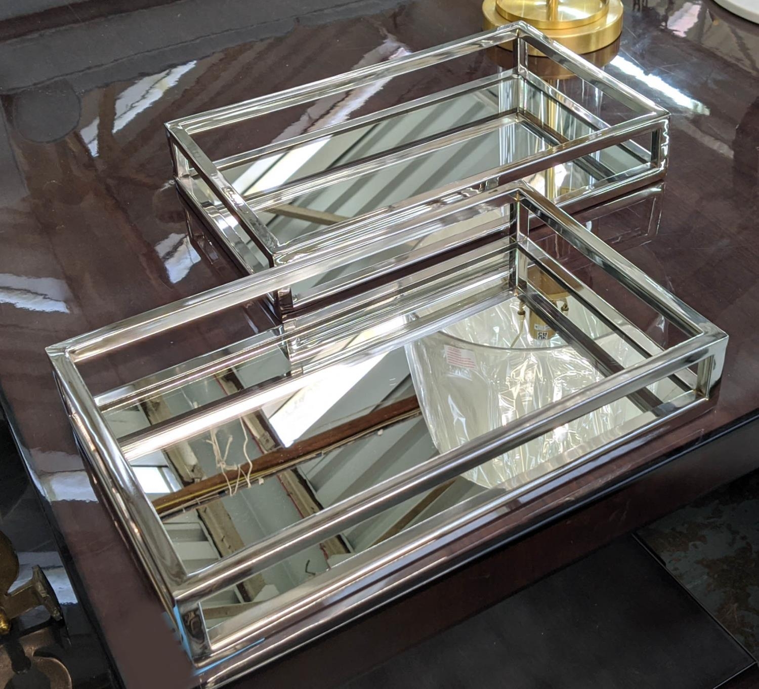 COCKTAIL TRAYS, a pair, mirrored with polished metal detail, 39.5cm x 24.5cm x 7cm. (2)