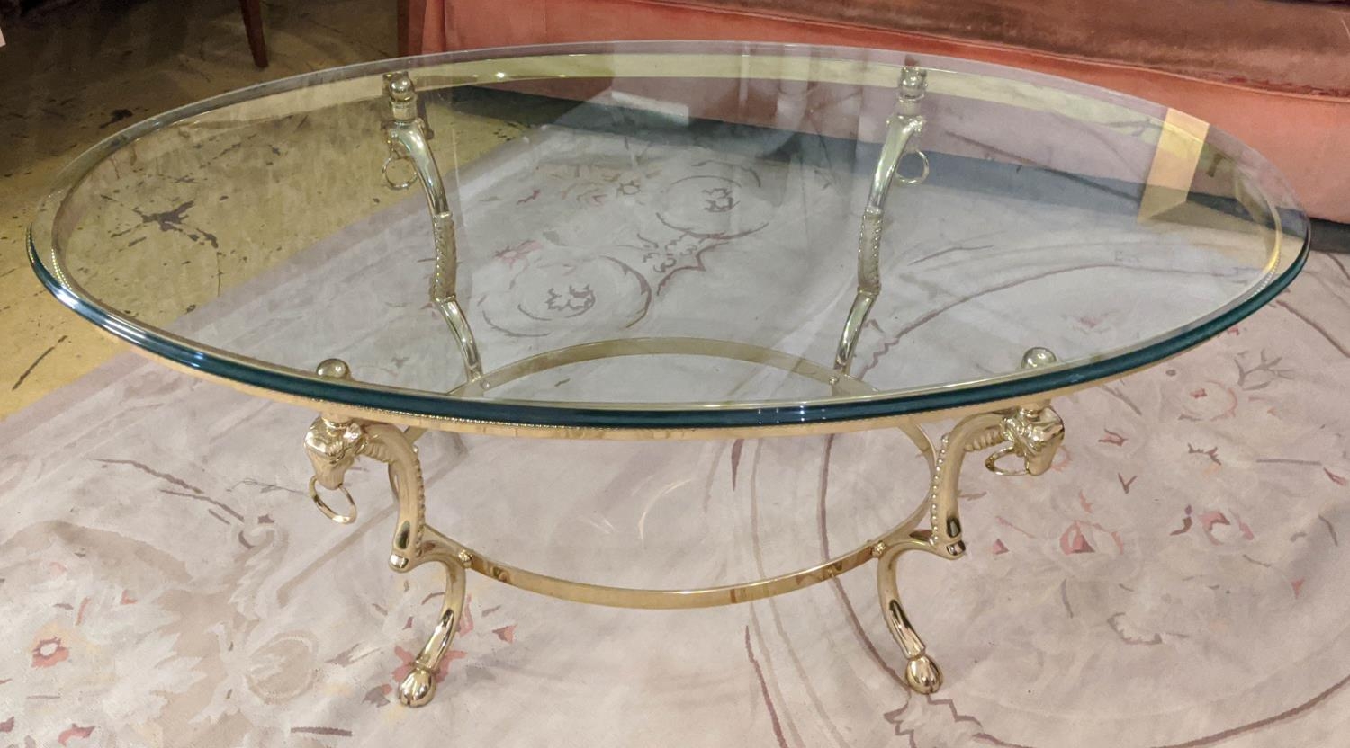 MAISON JANSEN STYLE COCKTAIL TABLE, rams head detail, gilt metal and glass, 126cm x 71cm x 51cm.