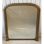 OVERMANTEL MIRROR, late 19th century English carved giltwood with arched moulded frame and