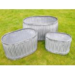 TROUGH PLANTERS, a graduated set of three, largest measuring 35cm high, 64cm long, 40cm wide,