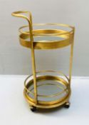 COCKTAIL TROLLEY, 77cm high, 42cm diameter, 1960s French style, mirrored glass tiers, gilt metal