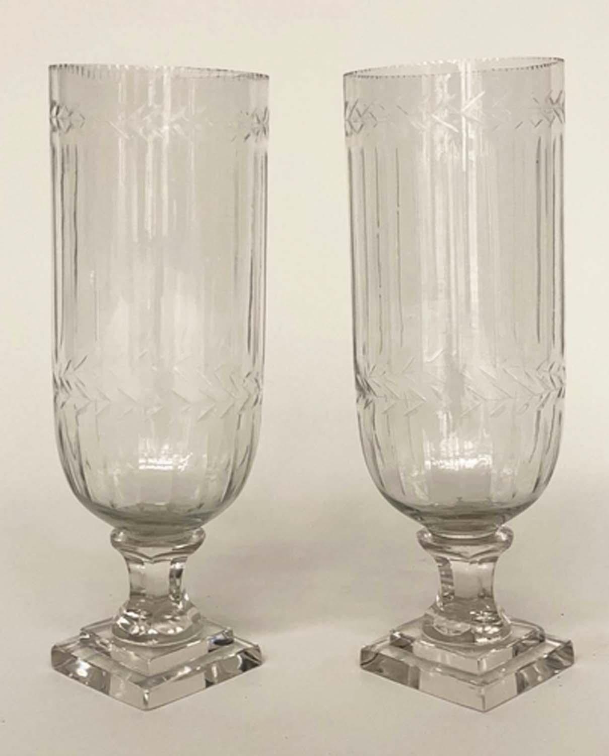 STORM LANTERNS, a pair, cut glass and engraved, cylindrical with facetted stepped plinths, 34cm