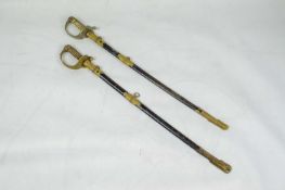 THAI NAVY OFFICERS ELEPHANT HEAD DRESS SWORDS, two, in black leather scabbards with brass mounts. (