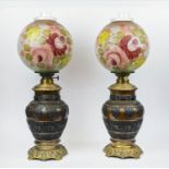 A PAIR OF 19TH CENTURY BRONZE AND BRASS OIL LAMPS, the baluster bodies with cast motifs and bands of