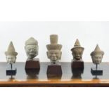 A COLLECTION OF MOUNTED ASIAN STATUE HEADS, five various one in volcanic rock and one sandstone,