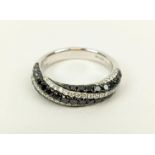 AN 18CT WHITE GOLD DIAMOND SET RING, with spiral bands of black and white diamonds, open gallery
