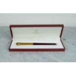 MUST DE CARTIER BALLPOINT PEN, gold plated and red marbalised lacquer finish, in original box.
