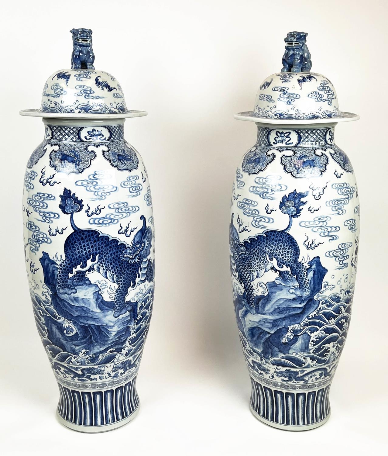 LIDDED TEMPLE VASES, a pair, Chinese blue and white decorated with mythical lions, dragons bats