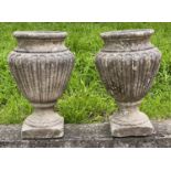 GARDEN URNS, a pair, well weathered reconstituted stone of vase form with reeded side, 44cm H. (2)