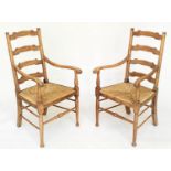 ARMCHAIRS, a pair, early 20th century English oak with ladder backs and rush seats, 55cm W. (2)